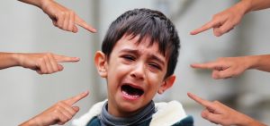 Traumas psicológicos: criança chorando e dedos apontados para ela