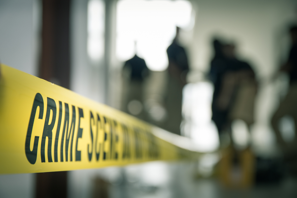 Hipnose forense: faixa amarela escrito "CRIME SCENE", e pessoas desfocadas no fundo de uma sala.