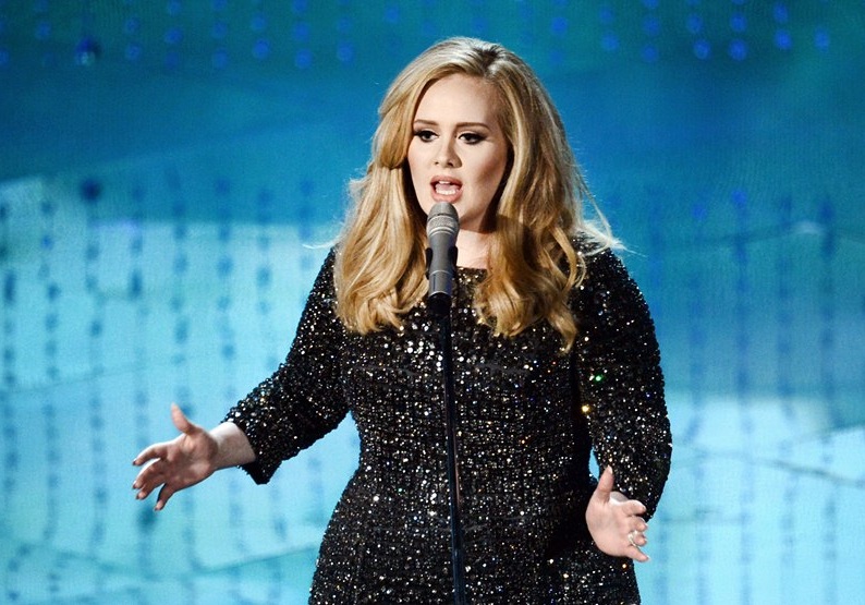 hipnose clínica: cantora Adele em um vestido preto, cantando com um microfone à sua frente