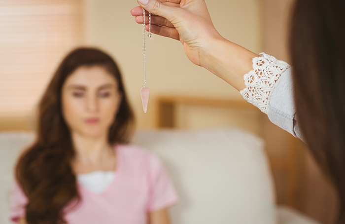 Qual o problema em se usar a pseuhipnose? Mulher sendo hipnotizada por um pêndulo